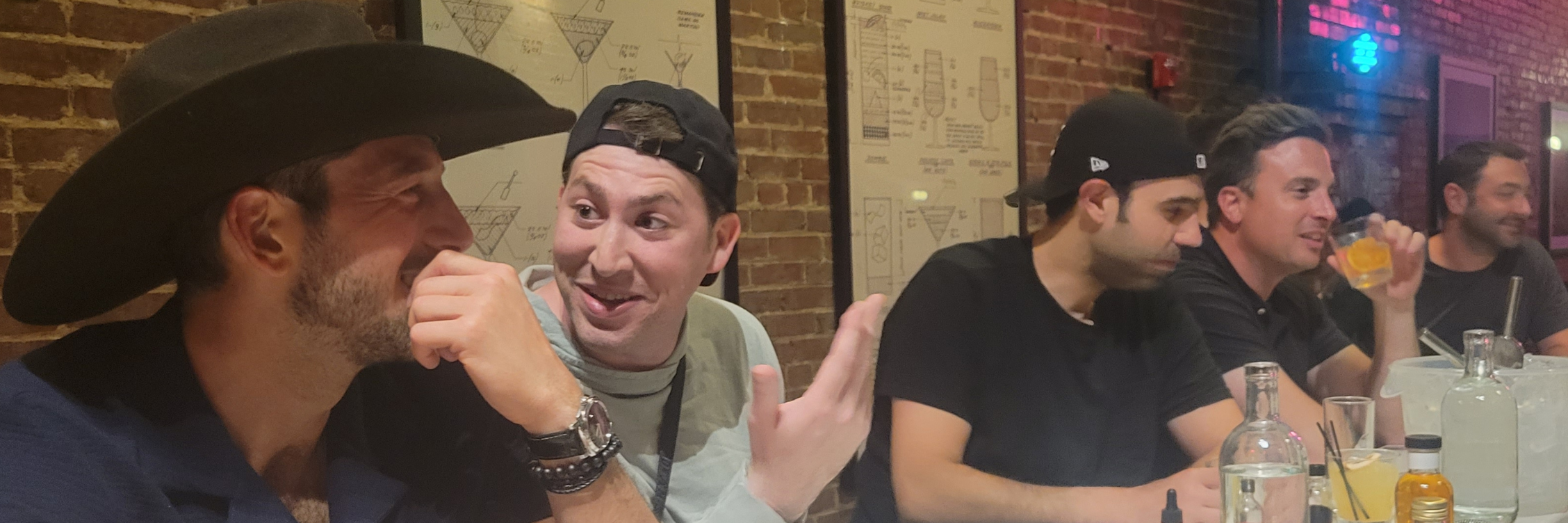 Group of friends laughing together at a table with drinks