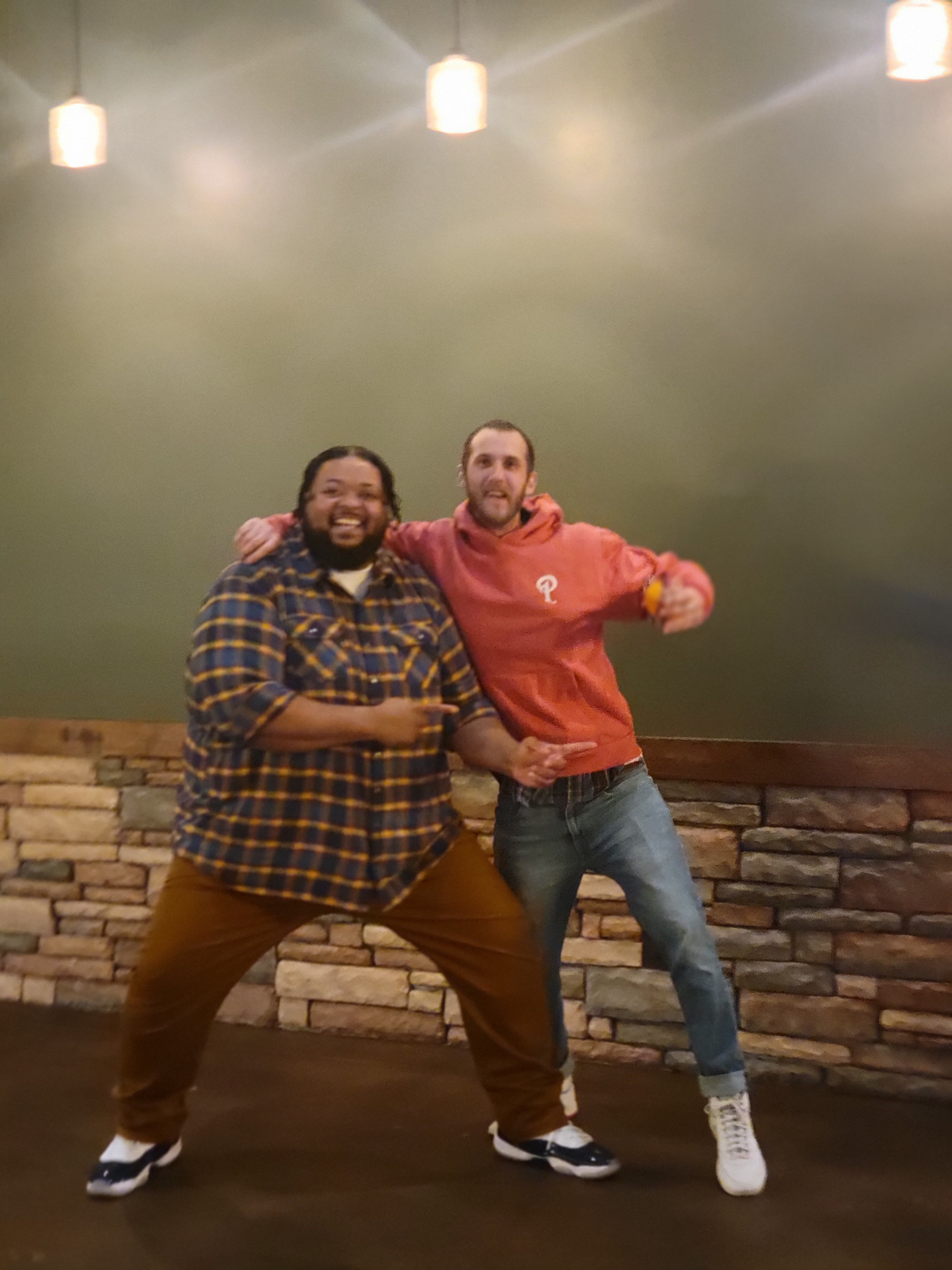 Two friends dancing and laughing together at the venue